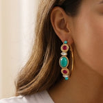 Boucles d'oreilles créoles larges dorées à tiges percées, turquoise, cabochon et cristaux grenat, diamètre 5 cm, collection Fujita – photo portée