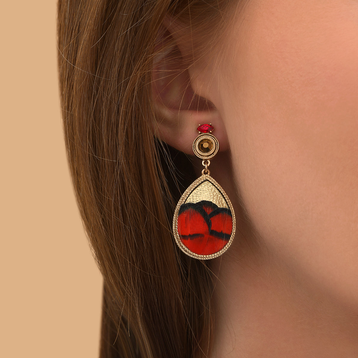 Boucles d'oreilles clips dorées en marqueterie de plumes naturelles rouges et cuir d'agneau doré, cristal Prestige et perles du Japon, collection Fujita – photo portée