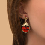 Boucles d'oreilles clips dorées en marqueterie de plumes naturelles rouges et cuir d'agneau doré, cristal Prestige et perles du Japon, collection Fujita – photo portée