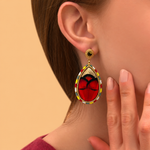 Boucles d'oreilles clips dorées à plumes naturelles rouges, cuir doré, cristal et perles du Japon, collection Fujita – photo portée
