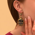 Boucles d'oreilles dormeuses pendantes dorées à plumes naturelles beiges, cuir doré, cristal et perles du Japon, collection Fujita – photo portée
